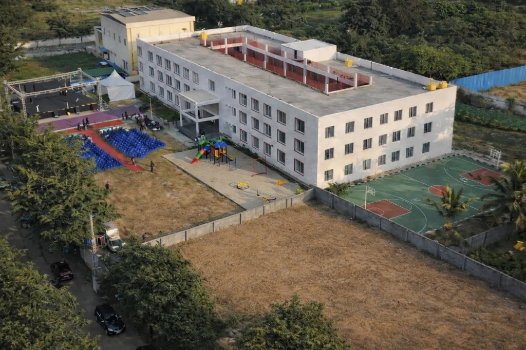 Aerial view of the Sumedha International School campus, playground and sports court